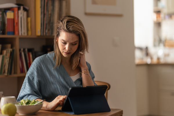 Portrait of young woman in her apartment working on a laptop.