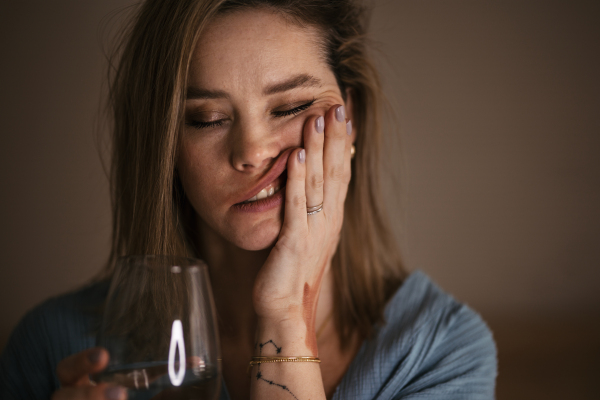 Portrait of depressed woman with a glass of wine.