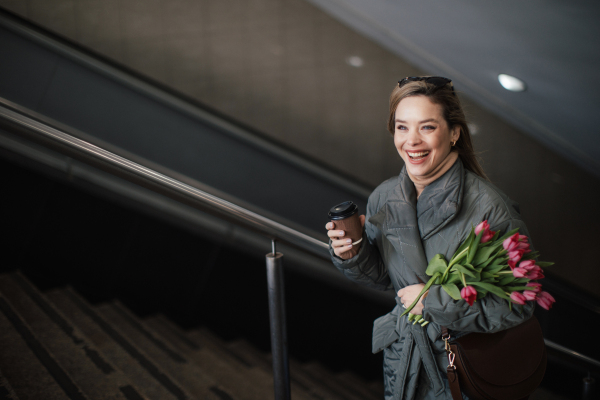 Young woman in a city with a bouquet of tulips.