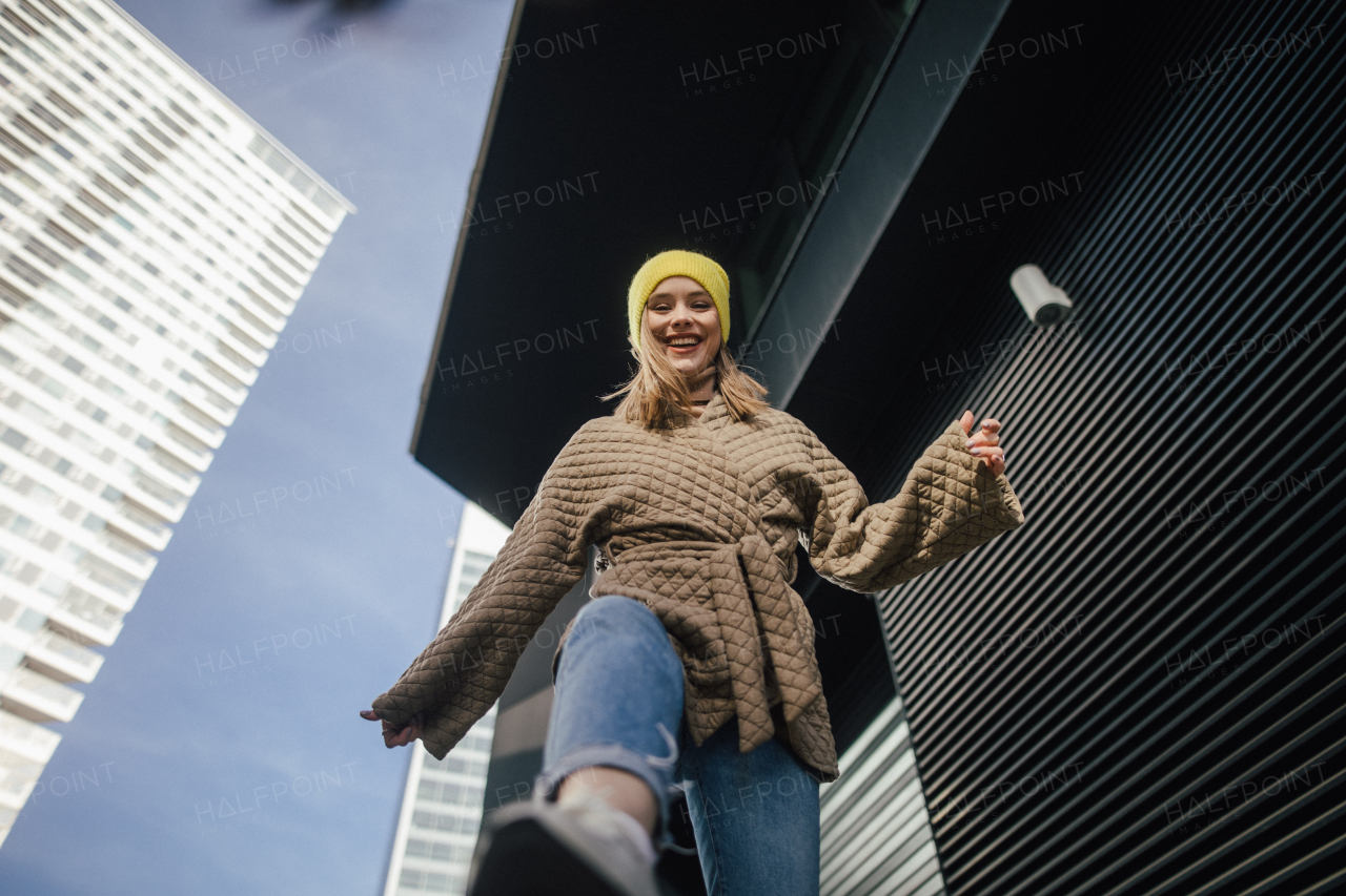 Low angle view of young fashionable woman in city.