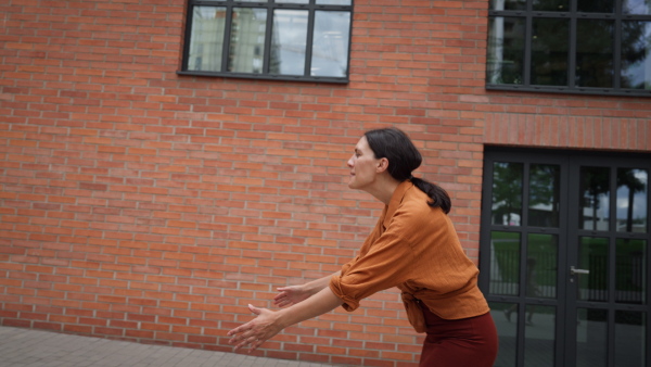 A hard-working, ambitious mother picking up son from school, greeting him in front of the school building, and heads to work. Concept of work-life balance for women.