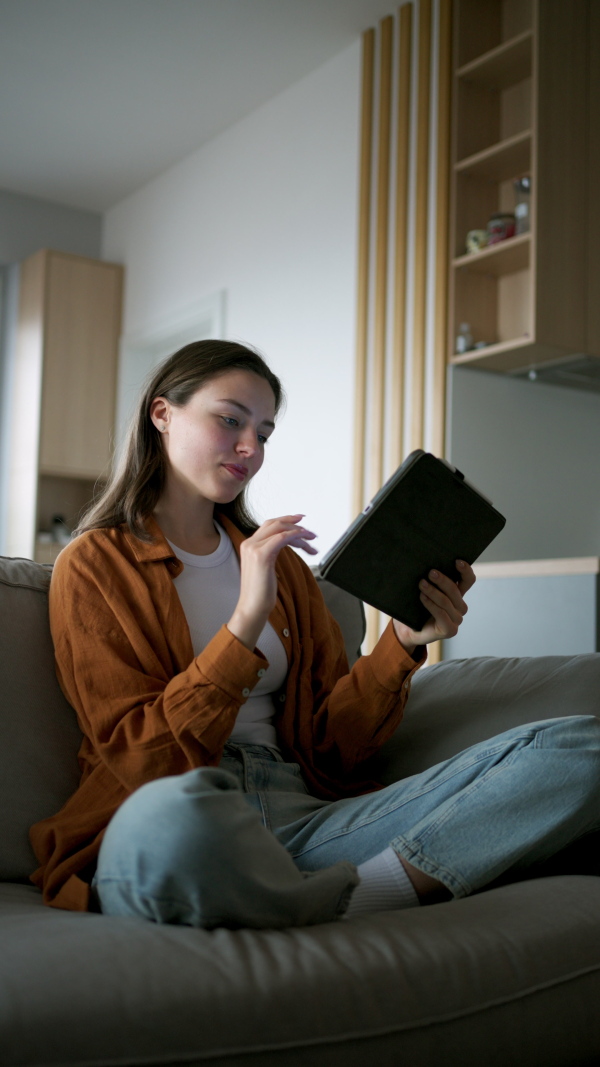 A woman with tablet managing household functions of smart home system. Online shopping, e-commerce.