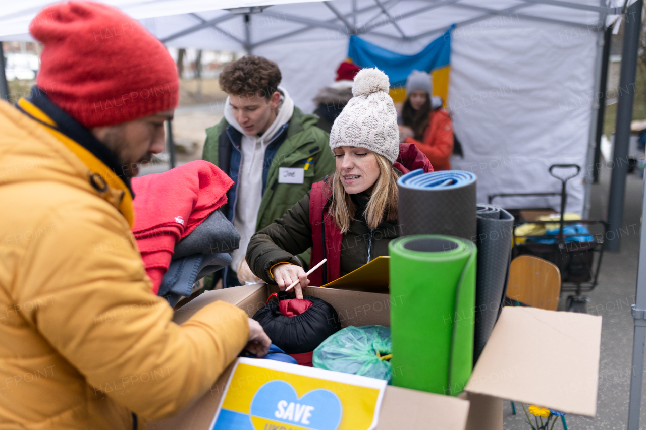 The volunteers distributing food and drink to refugees on the Ukrainian border, humanitarian aid concept.