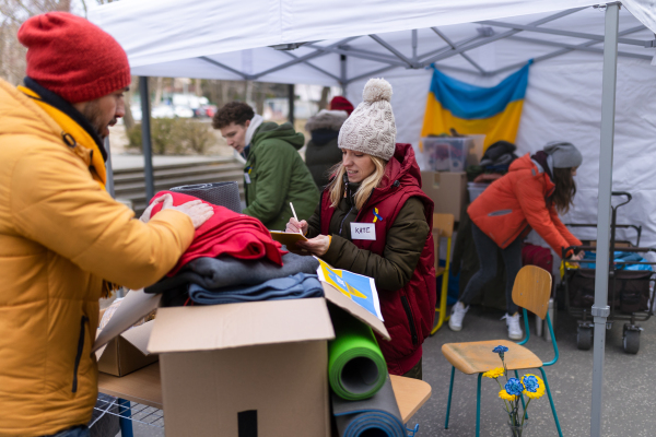 The volunteers distributing dontaions to refugees on the Ukrainian border, Russian-Ukrainian war concept.