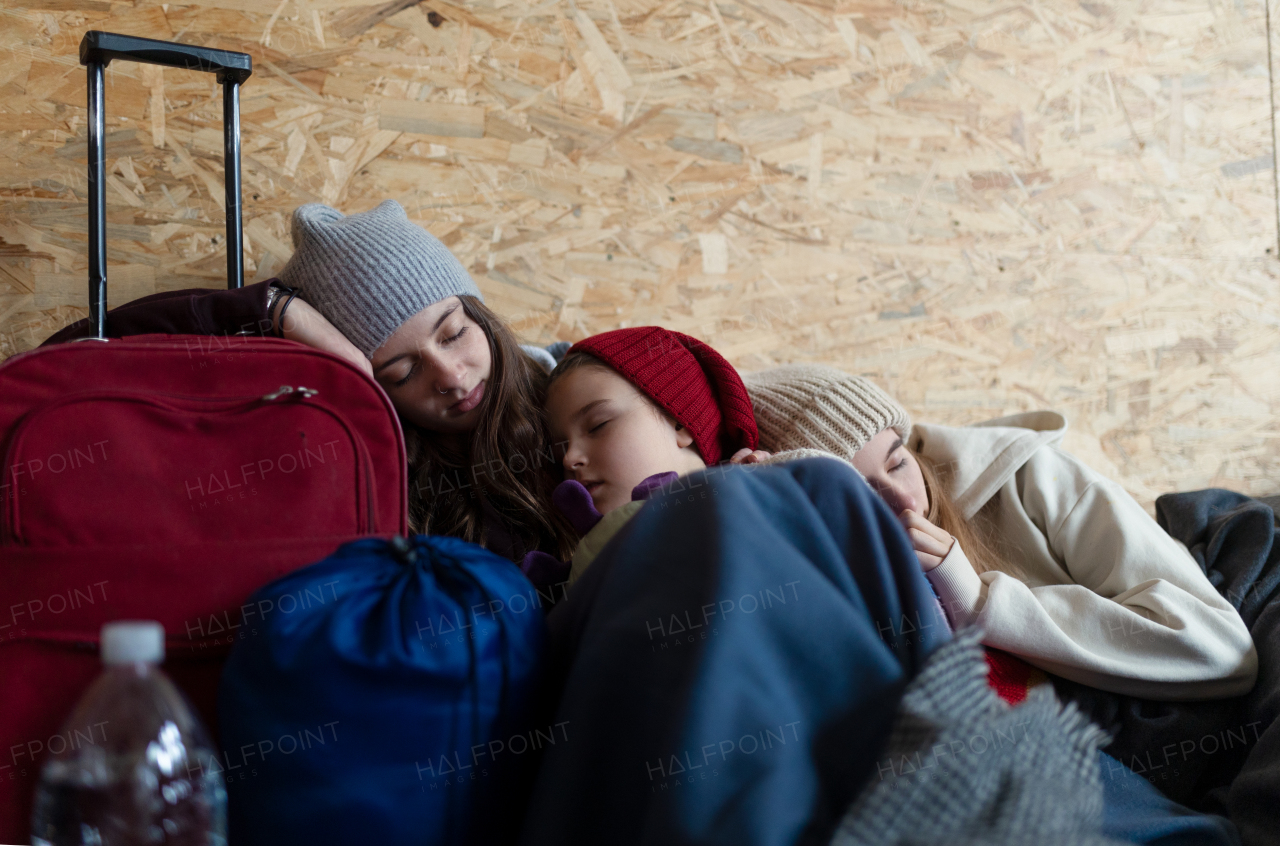 The Ukrainian war refugees in temporary shelter and help center, children tired and sleeping.