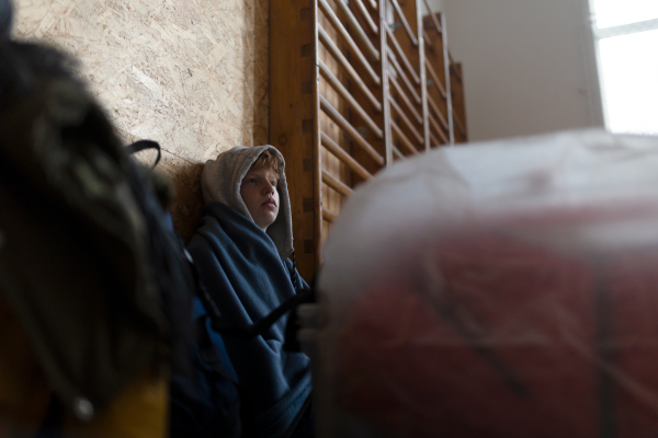 An Ukrainian teenage boy war refugee in temporary shelter and help center.