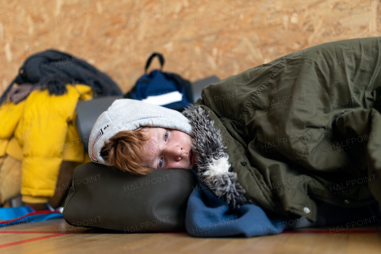 An Ukrainian teenage boy war refugee in temporary shelter and help center.