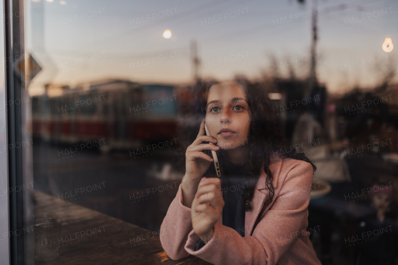 A young woman calling and enjoying her leisure time alone in cafe