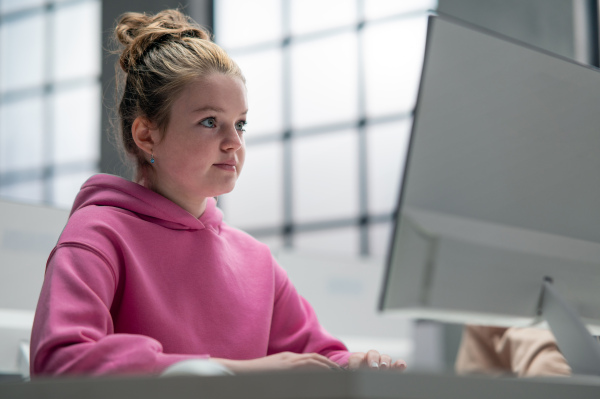 A schoolgirl using computer in classroom at school