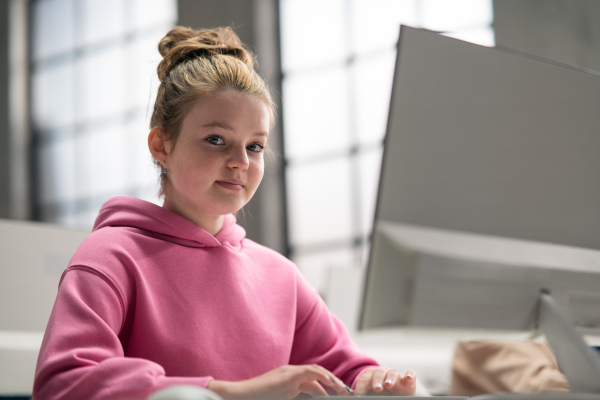 A schoolgirl using computer in classroom at school