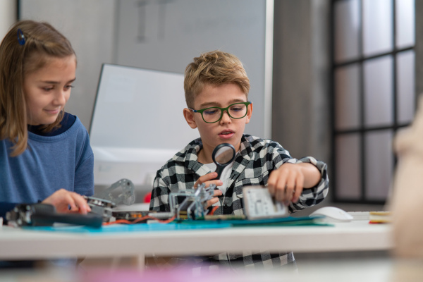 Pupils at school working with electronics component at a robotics classroom.