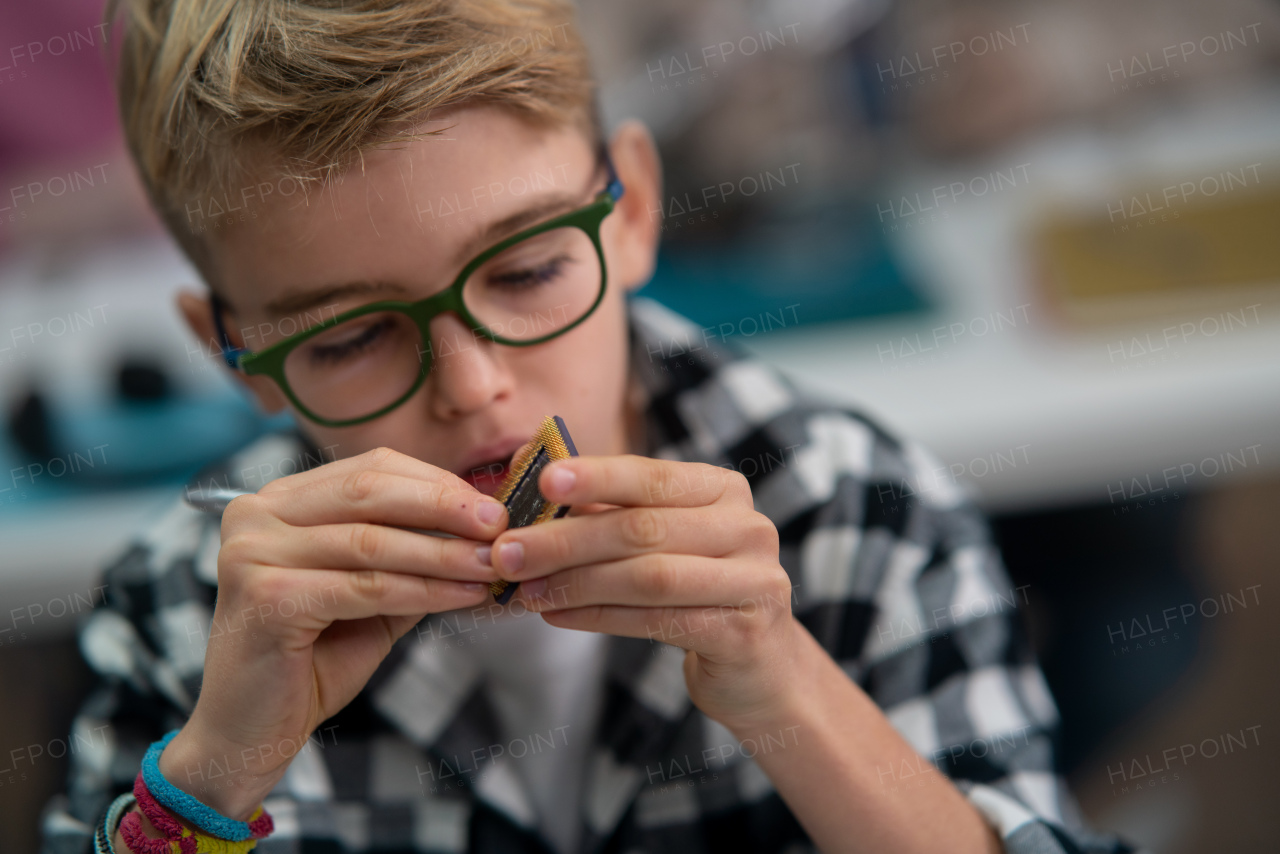 A pupil in school working with electronics component at robotics classroom.