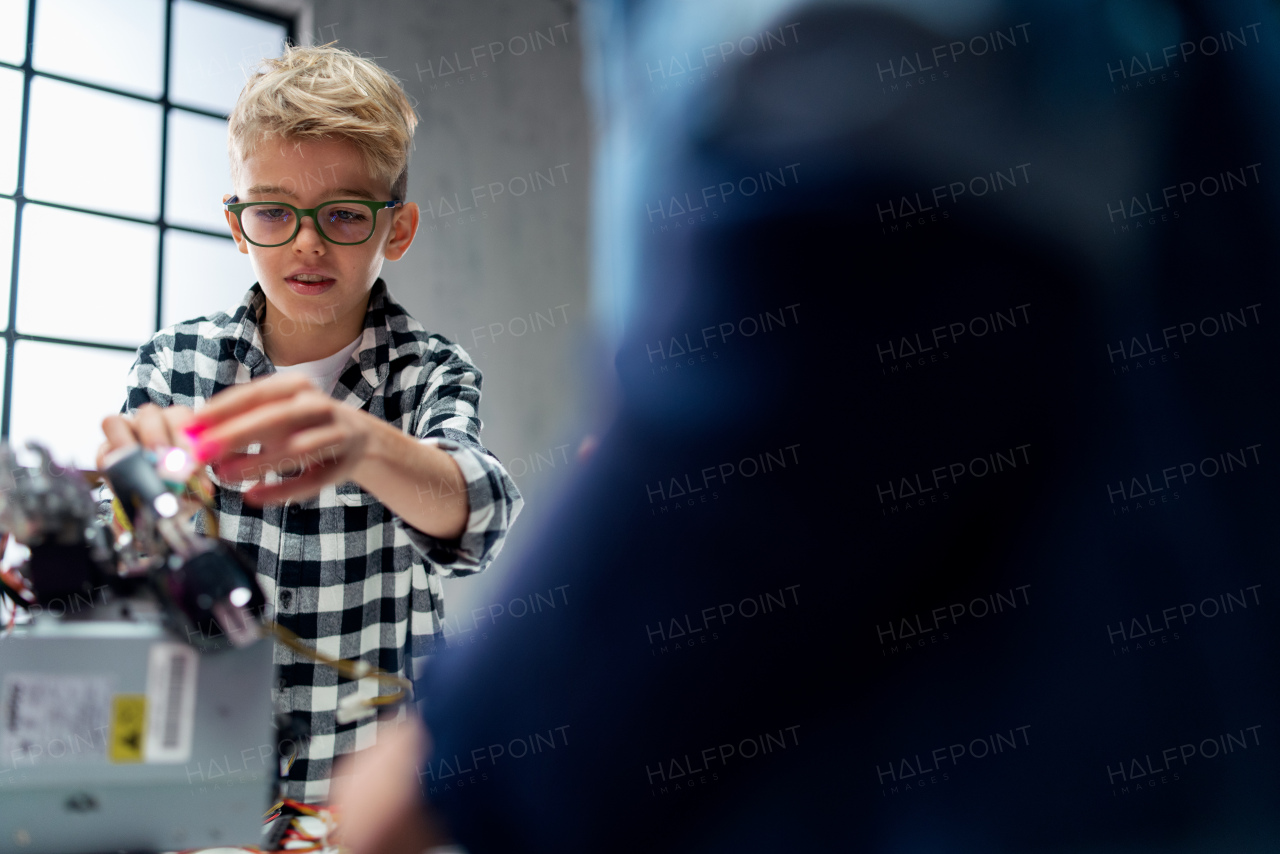 Pupil at school working with electronics component at a robotics classroom.