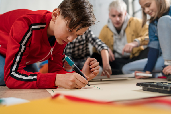 A group of happy kids with their science teacher with electric toys and robots at robotics classroom