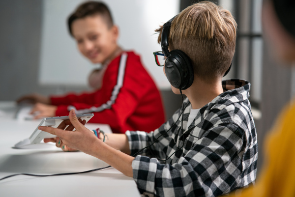 A schoolboy using computer in classroom at school