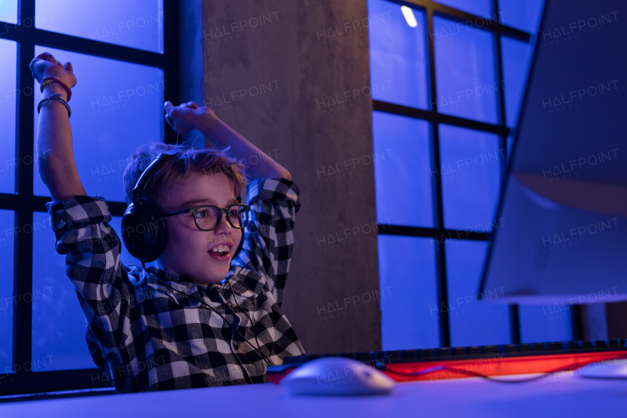 cheerfull gamer boy with headphones playing a computer video game.