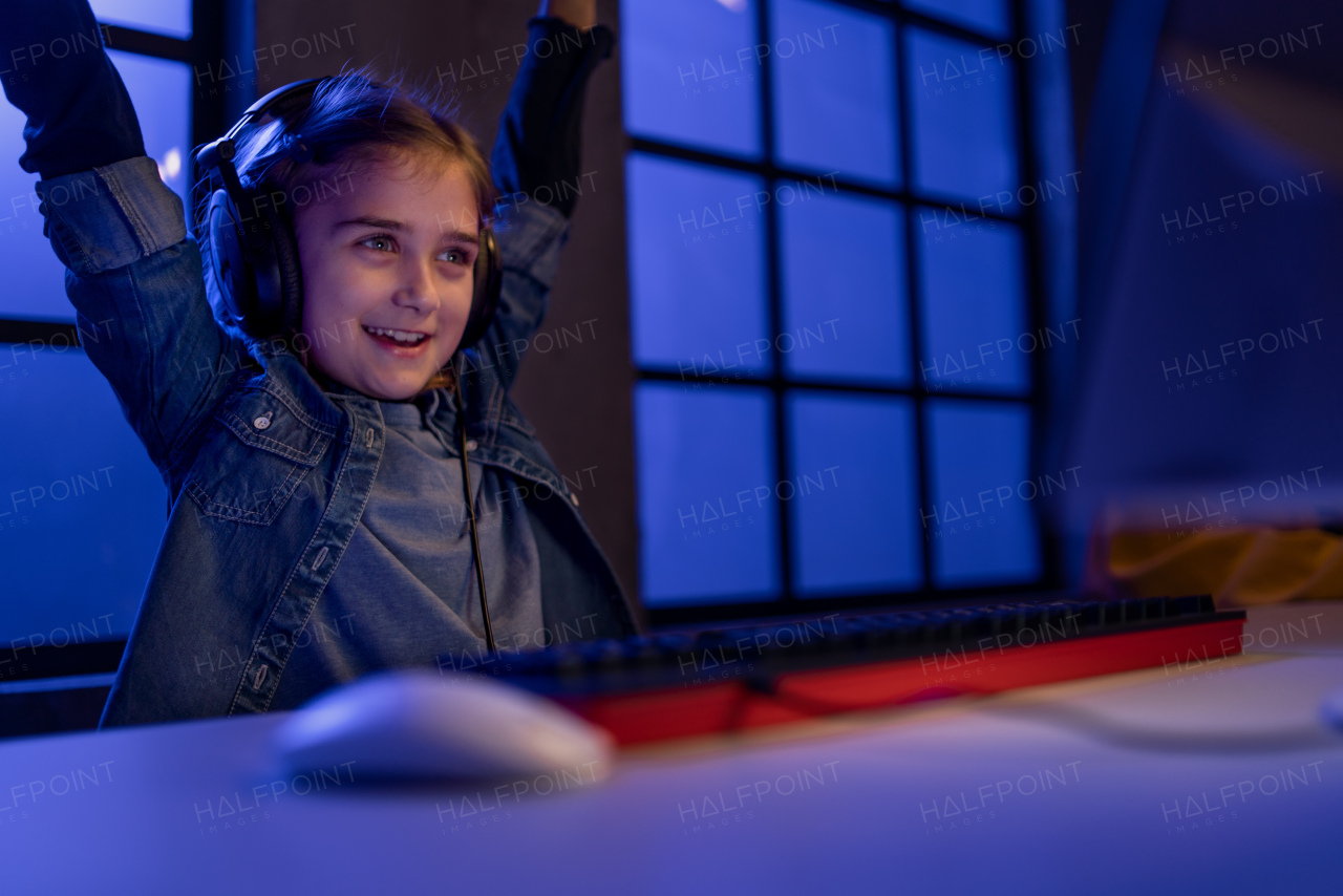 cheerfull gamer girl with headphones playing a computer video game.