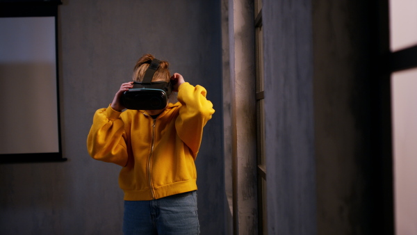 A schoolgirl wearing virtual reality goggles at school in computer science class