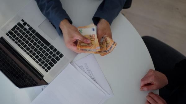 A businessman giving money to his partner while making contract - bribery and corruption concepts