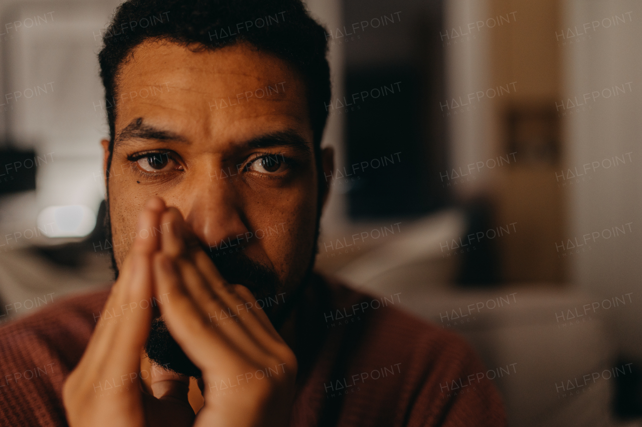 A portrait od depressed young African - American man, looking at camera.