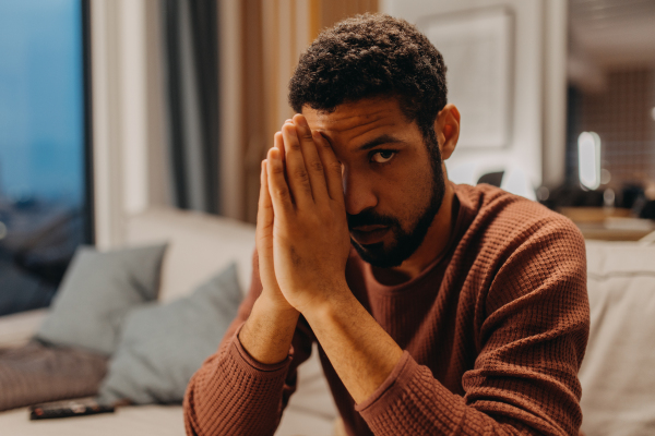 A portrait od depressed young African - American man, looking at camera.