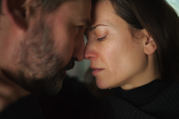 A close-up of woman crying when hugging her husband.