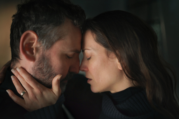 A close-up of woman crying when hugging her husband.