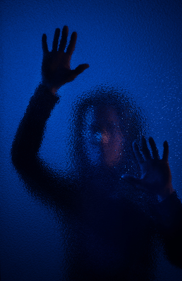 The shadow of woman screaming behind the glass, domestic violence concept.