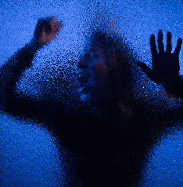 The shadow of woman screaming behind the glass, domestic violence concept.