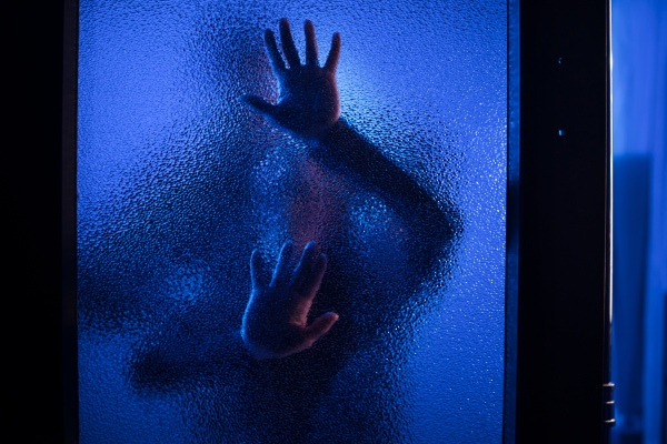 The shadow of woman screaming behind the glass, domestic violence concept.