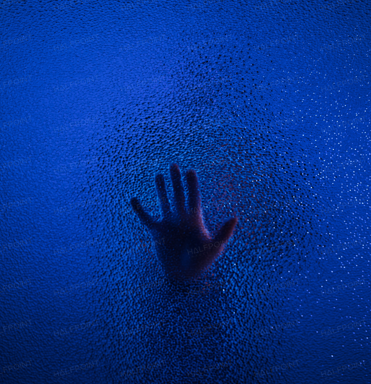 The shadow hand of a human behind the glass.