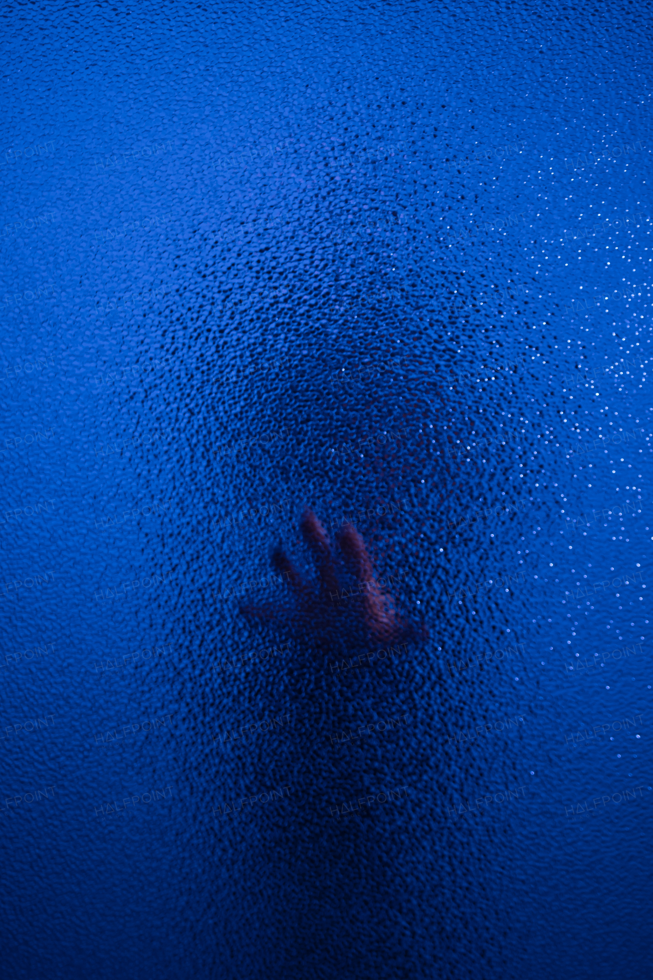 The shadow hand of a human behind the glass.