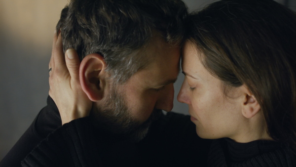 A close-up of woman crying when hugging her husband.