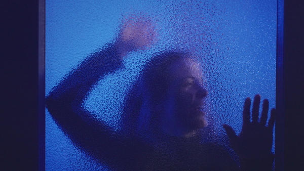 The shadow of woman screaming behind the glass, domestic violence concept.