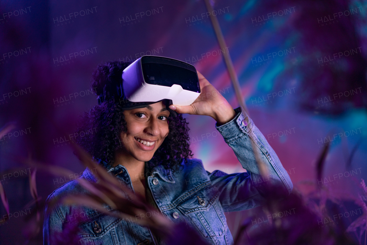 Metaverse digital cyber world technology, girl with virtual reality VR goggles playing augmented reality game, smiling, looking at camera,futuristic lifestyle