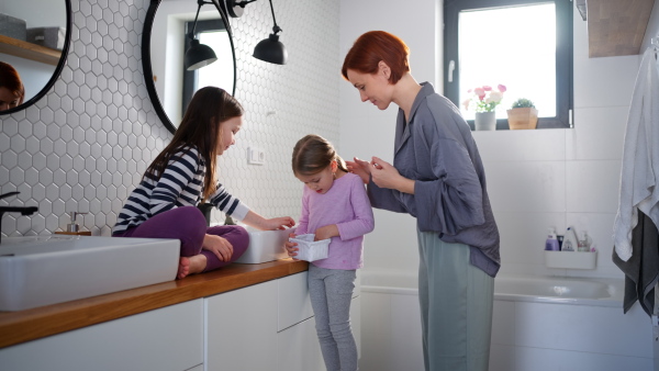 A mother with little children in bathroom, morning routine concept.