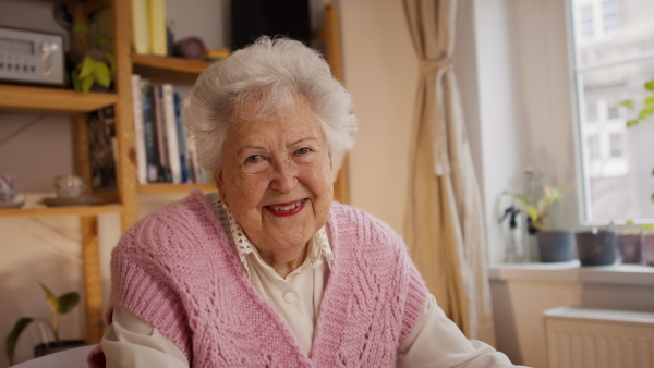 A happy senior woman at home and looking at camera