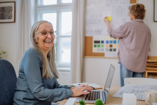 Happy mature women eco architects working together in an office.