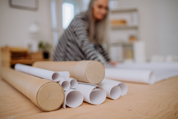 A close-up of architect blueprints in tubes in office.