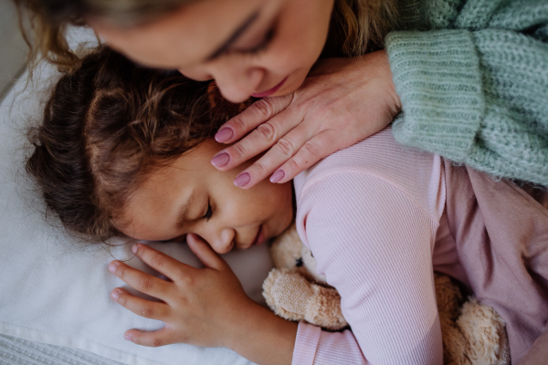 A close-up of mother taking care of her ill daughter at home.