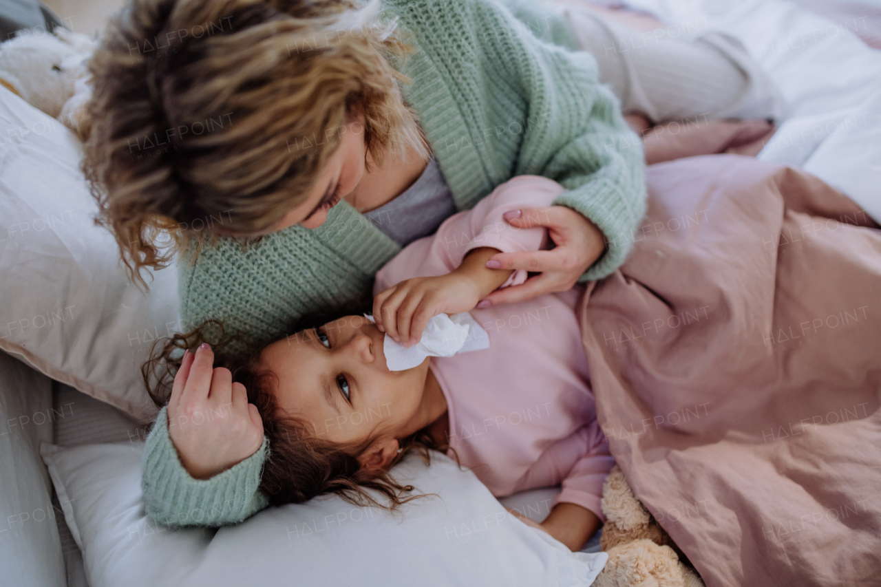 A mother taking care of her ill daughter at home.