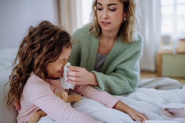 A mother taking care of her ill daughter at home.