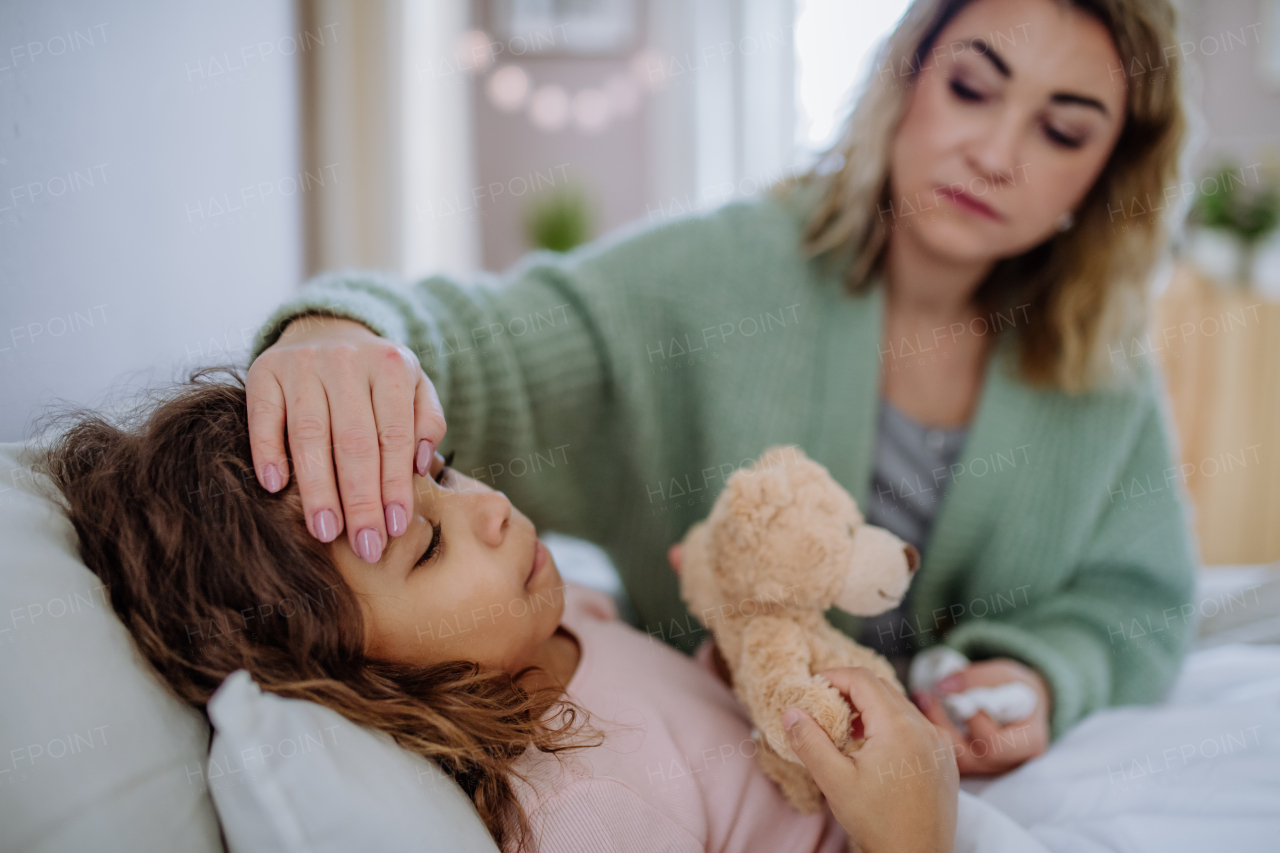 A mother taking care of her ill daughter at home.