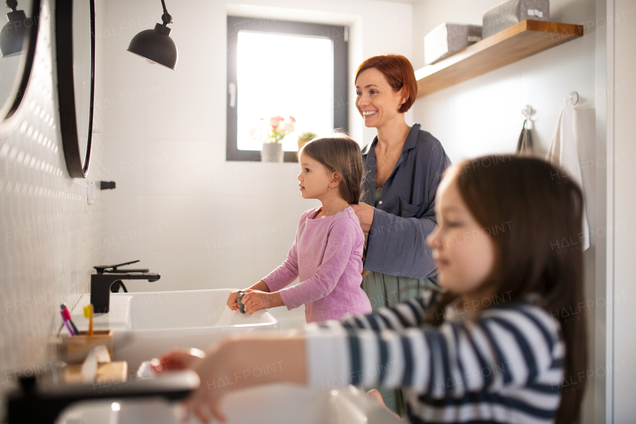 A mother with little children in bathroom, daily routine concept.