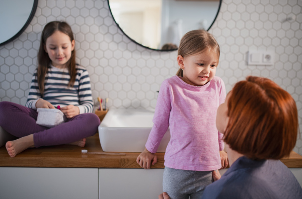 A mother with little children in bathroom, daily routine concept.