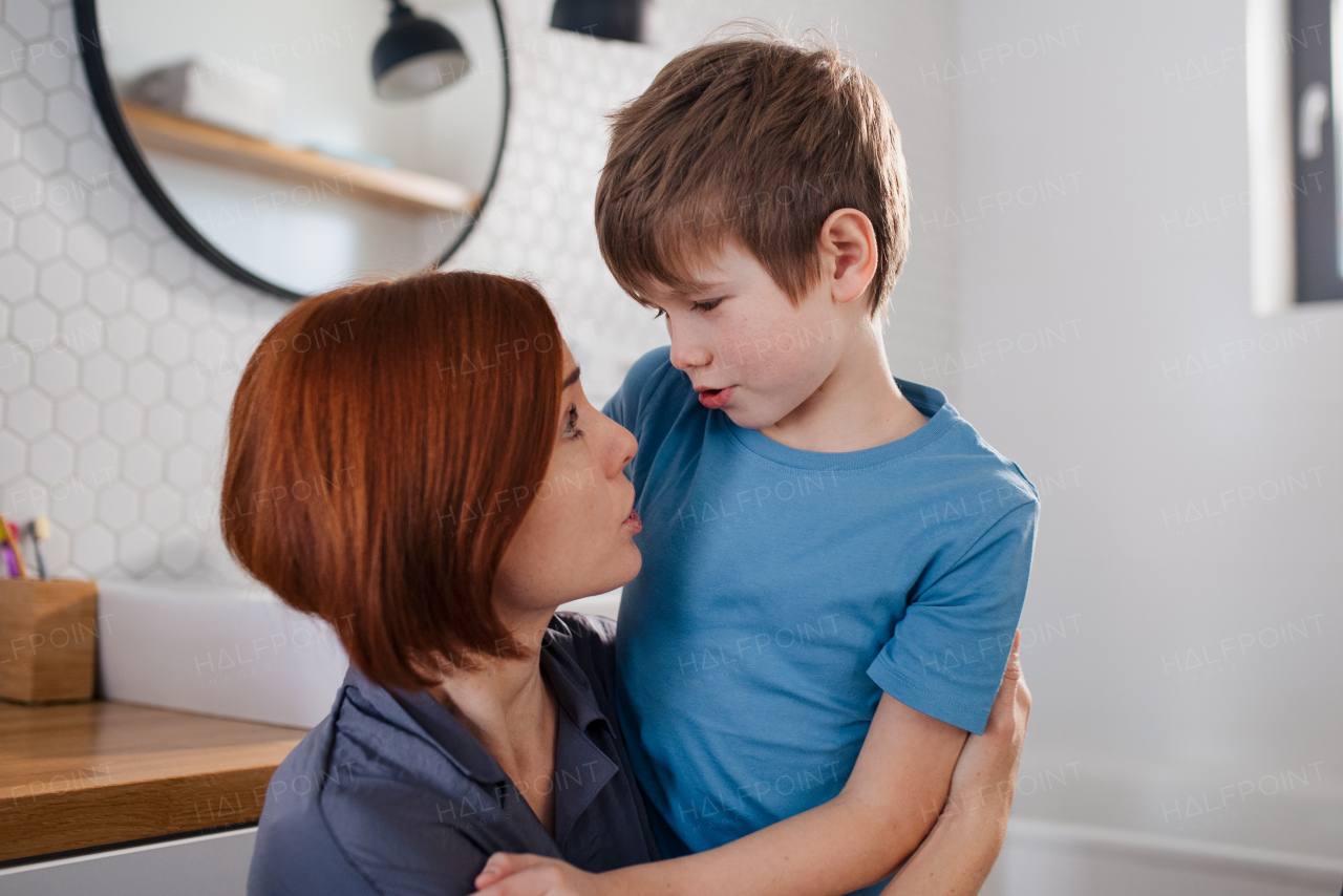 A mother talking with little son in bathroom at home.