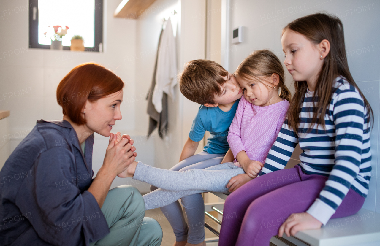 A mother with three little children in bathroom, morning routine concept.