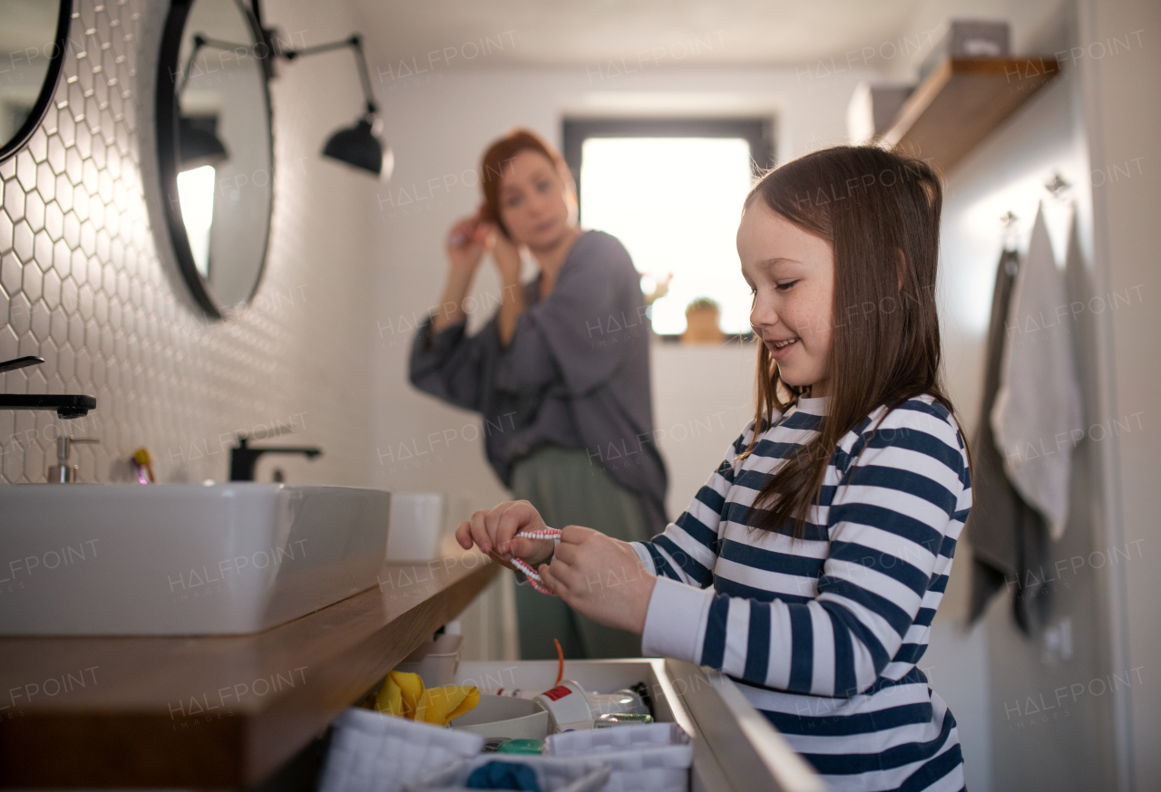 A mother with little daughter in bathroom, morning routine concept.