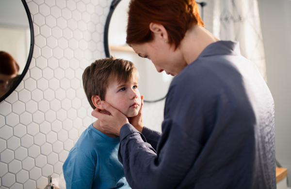 A mother talking with little son in bathroom at home.