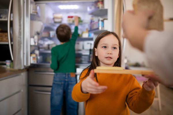 Little chidlren helping mother in the kitchen at home.